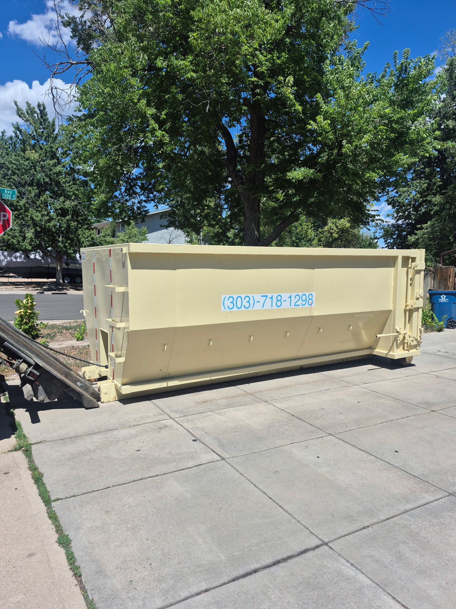 15 yard roll off dumpster parked on a residential driveway